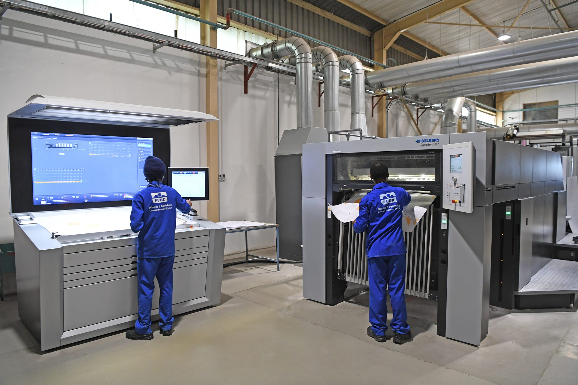 Press operators reviewing a print run